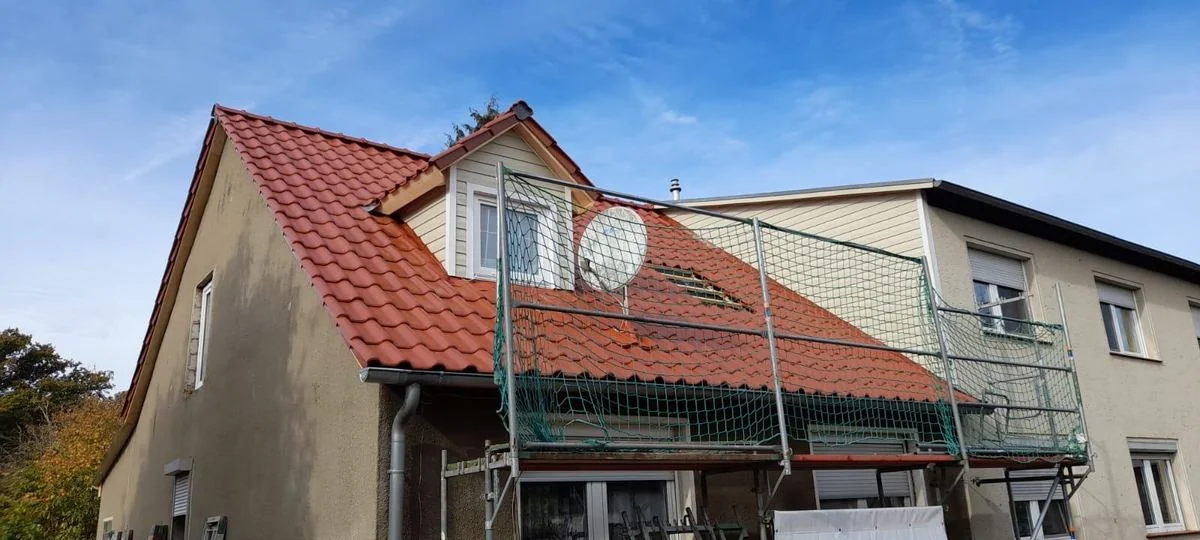 Neue Dachdeckung und erneuerte Gaube; das Gerüst steht noch